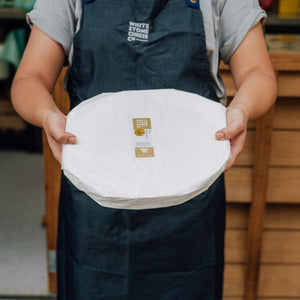 Staff holding large round of Lindis Pass Brie 
