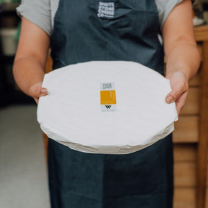 Staff holding 1.8kg round of Mt Domett Double Cream Brie